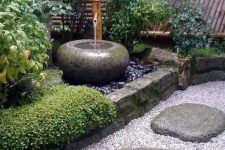 pebbles, rocks, grass, shrubs, a stone bowl fountain and a stone lantern for a lovely and chic Japanese front yard