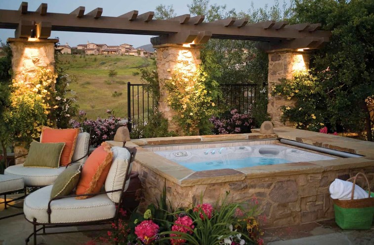 this above-ground hot tub offers sweeping views and is edged with stone for a more customized look