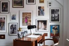a beautiful and refined home office with a rich-stained desk and a chair, a colorful gallery wall on an arched wall