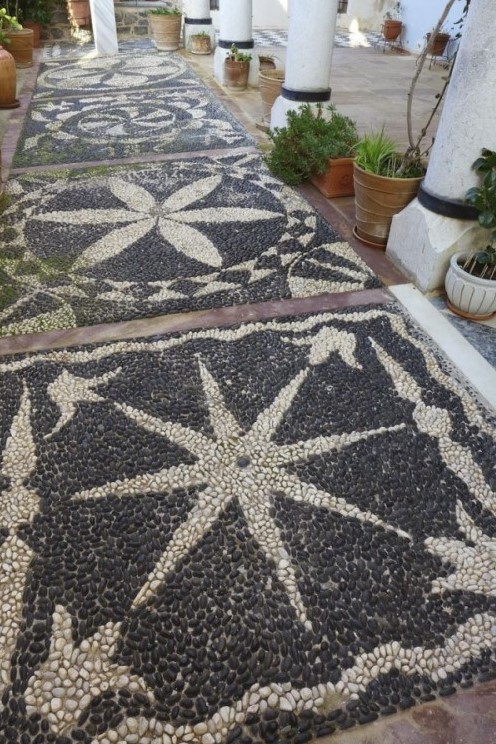 a beautiful pebble garden path with white and black pebbles and star and floral patterns