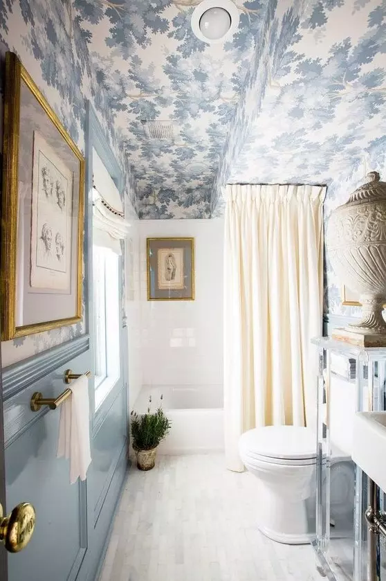 a beautiful vintage inspired blue and white bathroom with a printed wallpaper ceiling echoing the colors below