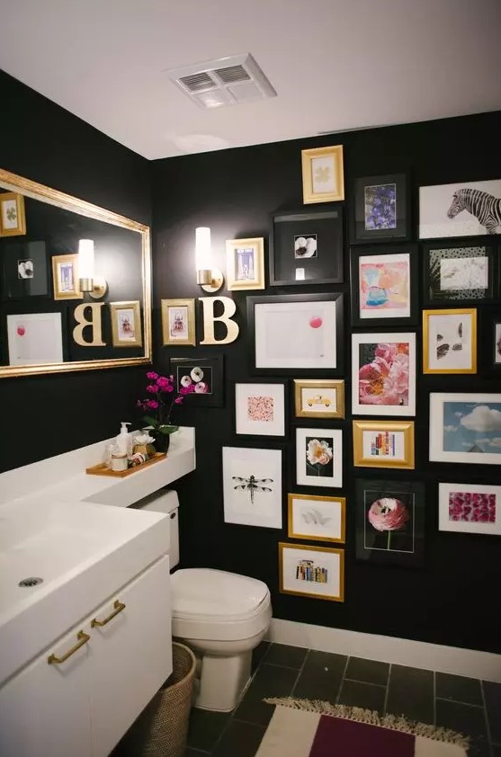a black bathroom with a white vanity and appliances, a bright gallery wall, a mirror and wall sconces is a cool space