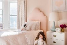 a blush girl’s bedroom accented with printed wallpaper on the ceiling looks more interesting and dreamy