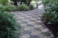 a bold and catchy garden path with black, burgundy, neutral pebbles and geometric patterns