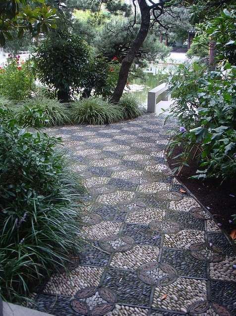 a bold and catchy garden path with black, burgundy, neutral pebbles and geometric patterns