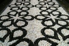a bold black and white pebble garden path with a catchy pattern is a bold mosaic decoration for your outdoor space