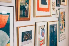 a bold gallery wall with a free shape, mismatching frames and colorful paintings, prints and posters with a vintage feel