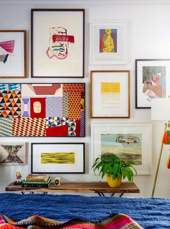 a bold gallery wall with colorful artworks, posters and prints and mismatching frames is a maximalist idea to rock