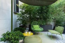 a bold patio with potted greenery, a woven mini roof, bold green metal seating furniture, a green pouf and a side table