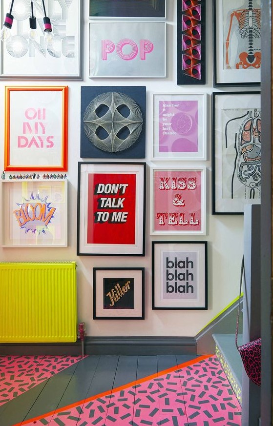 a bold pop art gallery wall with various posters and prints in bold colors is a very bright and fun idea for a colorful space