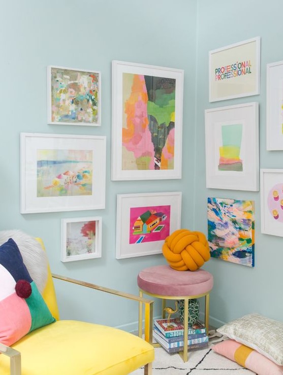 a bright and fun gallery wall taking two walls, with colorful abstract art and white frames
