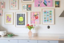 a bright and fun gallery wall with matching light stained frames and with no frames, with super bold artworks and posters