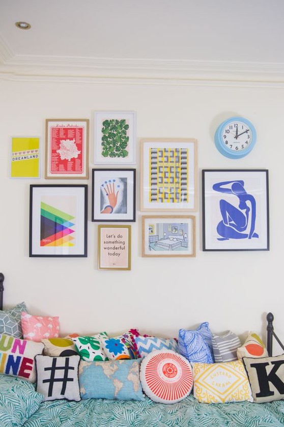 a bright gallery wall with bold posters and prints in mismatching frames will add a cool and cheerful touch to the space