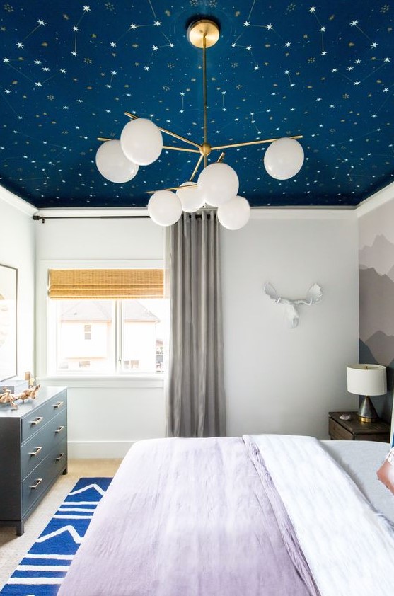 a celestial navy wallpaper wall makes the bedroom dreamy and trendy as everything celestial works