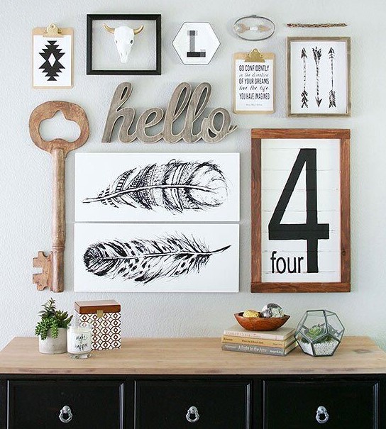 a chic mid-century modern gallery wall with a rustic feel - signs, a wooden key, some artworks and calligraphy is chic