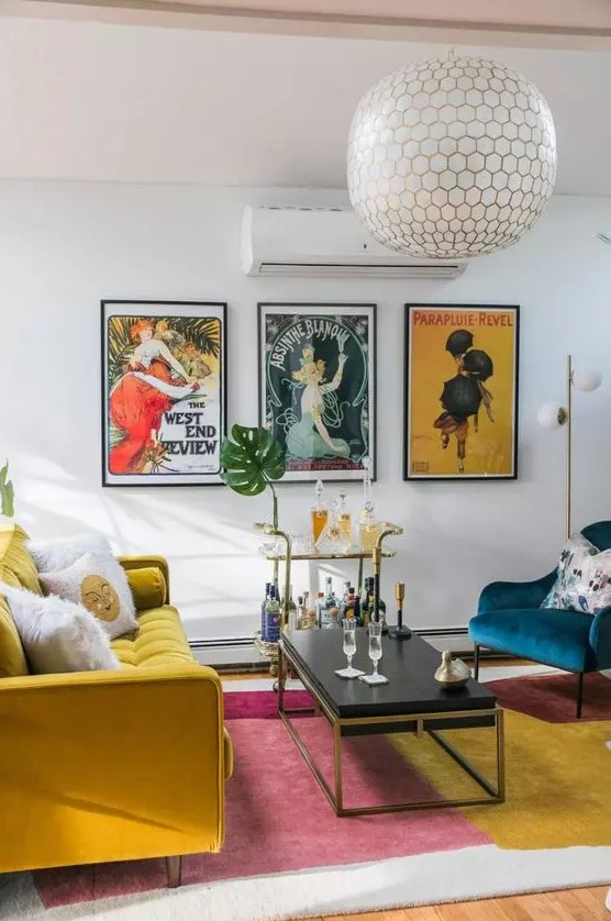 a colorful mid century modern living room with a mustard sofa, a navy chair, a color block rug and a bright vintage poster gallery wall