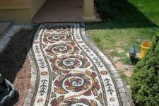 a colorful mosaic pebble garden path with yellow, red and green pebbles will accent your garden a lot