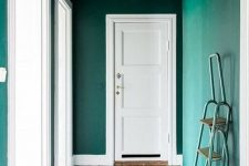 a completely emerald entryway with the ceiling that matches th walls and a bold rug is a great idea for a modern home