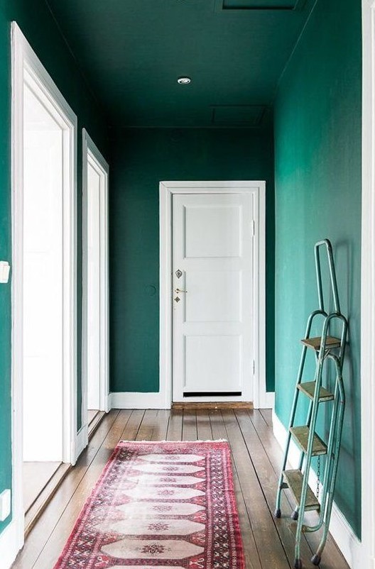 a completely emerald entryway with the ceiling that matches th walls and a bold rug is a great idea for a modern home