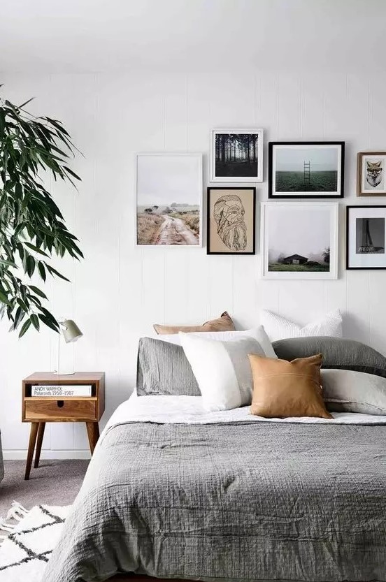 a contemporary gallery wall with a free form and mismatching frames plus prints and artworks that give it a modern feel