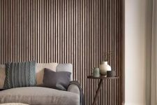 a contemporary living room with a wood slat accent wall, a taupe sofa and a textural pouf, a side table