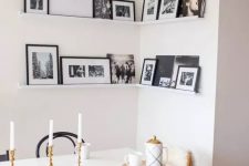 a corner gallery wall with black and white artworks in black frames adds personality to the space and makes it cozier