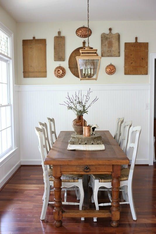 a dining room rustic gallery wall composed of old cutting boards and some wall lights is a cool idea for a rustic home