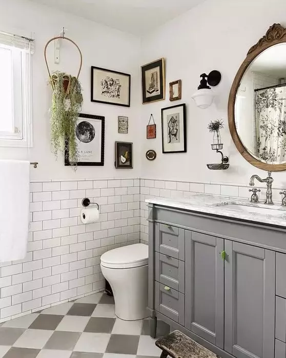 a farmhouse bathroom with white subway tiles, a grey vanity, white appliances, a vintage gallery wall and greenery, a mirror in a wooden frame