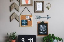 a farmhouse gallery wall with chevrons, a small artwork, a memo board, an arrow and a couple of air plants in holders