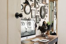 a farmhouse gallery wall with letters, signs and artwork, mini photos and silhouette art all in dark frames