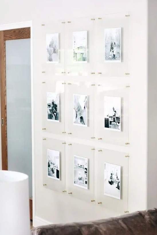 a floating gallery wall with clear acrylic frames and gold pins is a stylish idea that looks ultra modern and outstanding