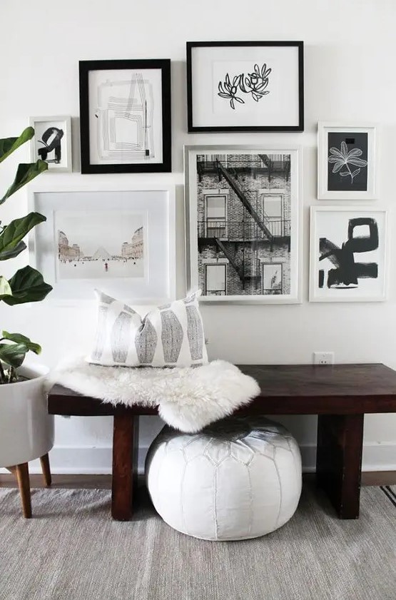 a free form black and white gallery wall with mismatching black and white frames and matting in some of them is a catchy idea