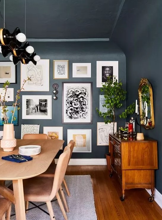 a free form gallery wall with framed and non-framed artworks, posters and prints plus some wall sconces is pure chic