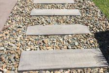 a garden path of river pebbles and concrete sleepers is a lovely idea for a modern garden or outdoor space