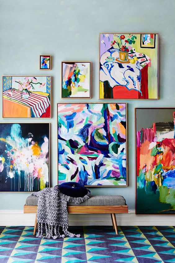 a jaw-dropping entryway with a printed rug, a grey bench, a colorful gallery wall that blows your mind off