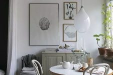 a lovely Scandinavian dining zone with a grey cabinet, a round table and vintage chairs, a mini gallery wall and some greenery