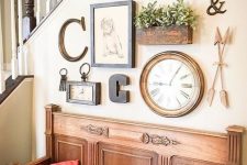 a lovely gallery wall with a clock, some artworks, monograms, potted greenery and faux taxidermy is a stylish solution
