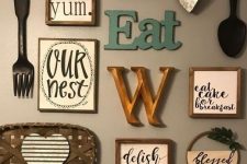 a lovely kitchen gallery wall with letters and monograms, signs in frames, pretty cutlery and a tiny wreath with greenery