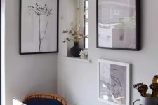 a lovely nook with a black chair with a pillow, a mini gallery wall and some dried blooms and plants