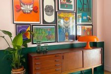 a mid-century modern living room with color block walls, a bold mid-century modern poster gallery wall and potted greenery
