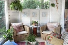 a mid-century modern to boho surnoom with rattan and woven furniture, with printed pillows and a bold rug and some potted plants