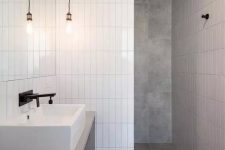 a minimalist bathroom done with grey tiles and white skinny stacked ones for an eye-catchy touch