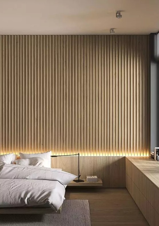 a minimalist bedroom with a light stained wood slat accent wall, a floating bed and nightstand, a built in windowsill storage unit