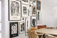 a monochromatic gallery wall with thin black and blonde wood frames and black and white artworks is a stylish idea