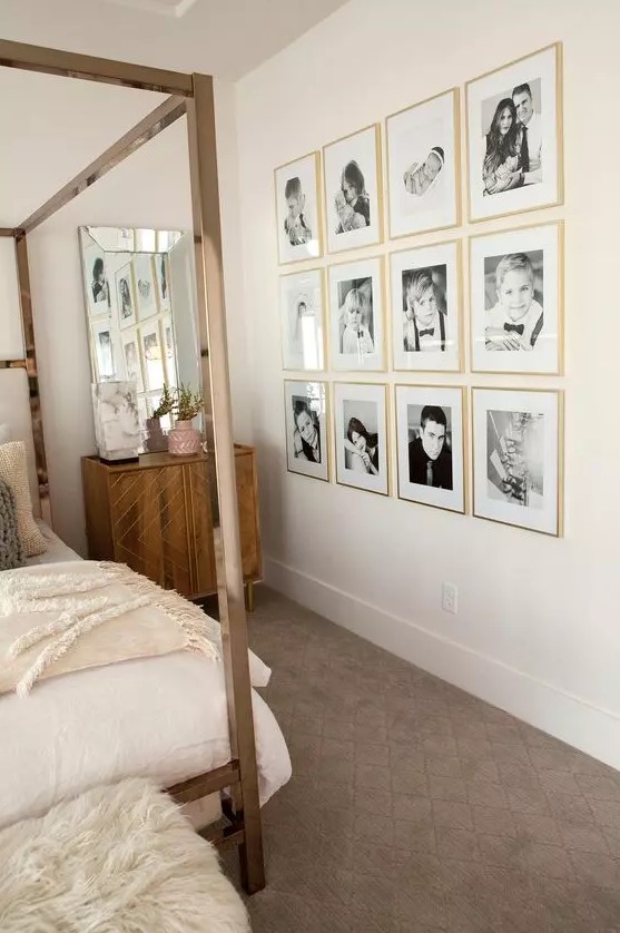 a neutral bedroom with stained furniture, a canopy bed with neutral bedding, a grid gallery wall with gold frames is lovely