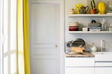A white kitchen with yellow accents