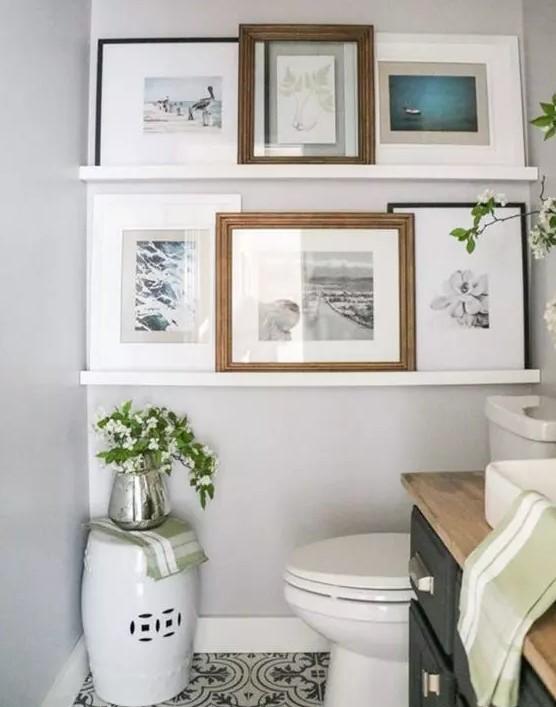 a neutral mudroom with a ledge gallery wall and seaside artwork, a grey vanity with a butcherblock countertop, white appliances