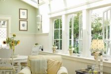 a neutral vintage sunroom with elegant and refined furniture in pastels, pendant lamps, lamps on the tables and much light