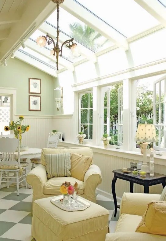 a neutral vintage sunroom with elegant and refined furniture in pastels, pendant lamps, lamps on the tables and much light