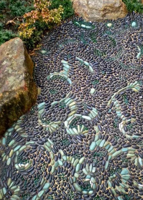 a pebble garden path done with patterns in mint green is a beautiful idea with a touch of color